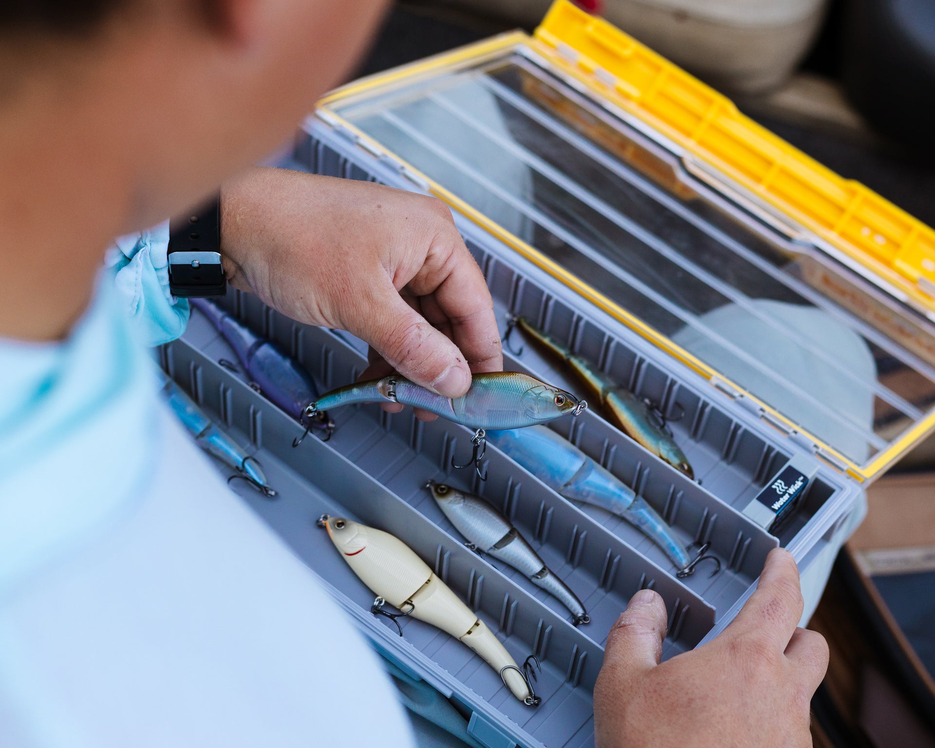 An angler removes a Magic Swimmer® Freshwater bait from his Plano Edge Stowaway