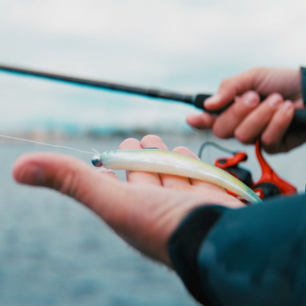 Person holding a fishing lure with a blurred background